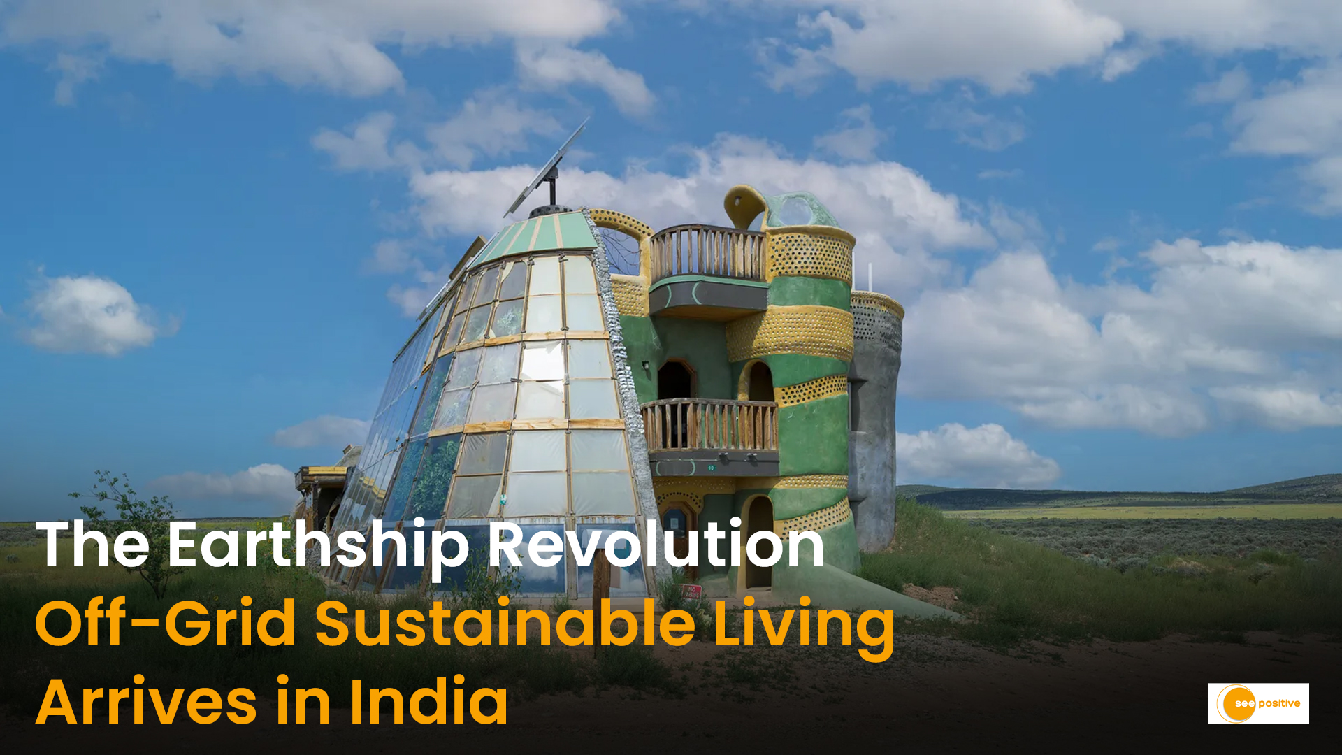 An Earthship home exterior with glass bottle walls, earthen plaster finish, and solar panels.